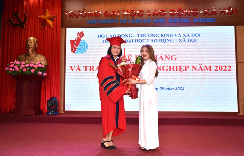 Tân Cử nhân Nguyễn Thị Quế Anh, thay mặt cho các em sinh viên vừa tốt nghiệp tặng quà cho TS. Doãn Thị Mai Hương - Phó Hiệu trưởng, đại diện Ban Giám hiệu Trường Đại học Lao động - Xã hội