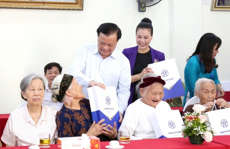 Bí thư thành ủy Hà Nội Đinh Tiến Dũng tặng quà thân nhân người có công với cách mạng. (Ảnh minh họa)
